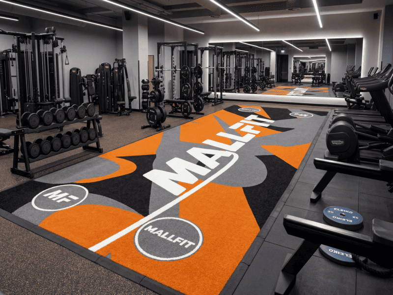 Staff member spraying antistatic solution on gym turf